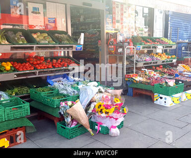 Flowers and a message left outside a shop in Uxbridge Road in Shepherd's Bush, west London, where detectives have launched a murder inquiry after a teenager was stabbed to death on Wednesday night. Stock Photo