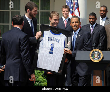 U.S. President Barack Obama accepts a team jersey from players  Brian Zoubek (L) and Jon Scheyer as he hosts the 2010 NCAA College Basketball Champion Duke Blue Devils in the Rose Garden of the White House in Washington on May 27, 2010.   UPI/Roger L. Wollenberg Stock Photo