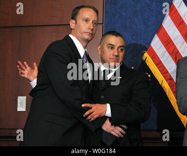 Marine Staff Sgt Eric Alva (R) and Air Force Major Mike Almy, both who were discharged for being gay, embrace during a press conference on the upcoming Senate procedural vote on the National Defense Authorization Act, which includes repealing 'Dont' Ask, Don't Tell,' in Washington on September 21, 2010.  UPI/Kevin Dietsch Stock Photo