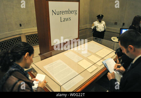 Members of the media look at the original Nuremberg Laws are seen on display at the National Archives in Washington on October 6, 2010. The laws, established by Adolf Hitler and the Nazis, restricted the rights of German Jews. UPI/Kevin Dietsch Stock Photo