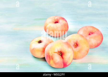 Vibrant organic saturn peaches on a teal background with a place for text Stock Photo