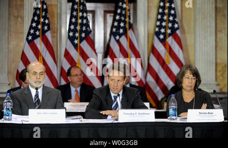 Treasury Secretary Timothy Geithner speaks as Federal Reserve Board Chairman Ben Bernanke (L) and FDIC Chair Sheila Bair (R) look on during the Financial Stability Oversight Council held a meeting to discuss mortgage servicing and foreclosure issues, and to vote on several resolutions to advance implementation of the Dodd-Frank Act, in the Cash Room of the Treasury building in Washington on November 23, 2010.     UPI/Roger L. Wollenberg Stock Photo