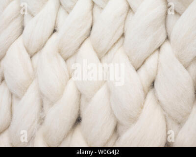 Merino wool handmade knitted large blanket, super chunky yarn, trendy concept. Close-up of knitted blanket, merino wool background Stock Photo