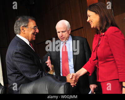 Defense Secretary Leon Panetta greets Sen. Kelly Ayotte (R-NH) as Sen. John McCain (R-AZ) reaches his hand out, prior to a Senate Armed Services Committee hearing on security issues relating to Iraq in Washington on November 15, 2011.  UPI/Kevin Dietsch Stock Photo