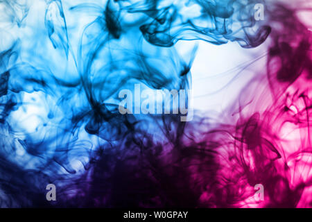 Blue and pink color ink flowed in water. Abstract blue and pink color ink pattern background. Stock Photo