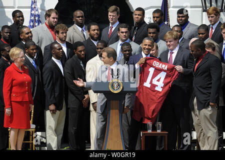 U.S. President Barack Obama accepts a team jersey from head coach