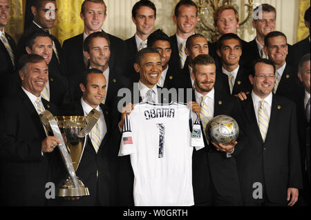 US President Barack Obama poses with a souvenir jersey as he is flanked by players David Beckham (R) and Landon Donovan (L), members of the LA Galaxy, Major League Soccer's Championship team at the White House, May 15, 2012, in Washington, DC.       UPI/Mike Theiler Stock Photo