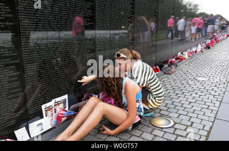 Young and old visit the Vietnam Veterans Memorial to reflect and pay their respects on the 50th anniversary of the Vietnam War on May 26, 2012 in Washington, DC.   More than 58,000 names of the servicemen who were killed or missing in the war are engraved on The Wall.  UPI/Pat Benic Stock Photo