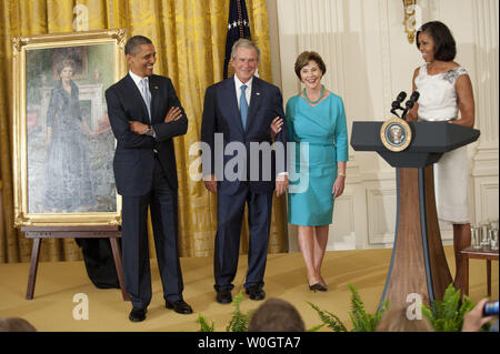 First Lady Michelle Obama delivers remarks alongside President Barack Obama (L), Former President George W. Bush and his wife Laura (2nd-R) at the unveiling ceremony for President George W. Bush's White House portrait in the East Room at the White House in Washington on May 31, 2012.  UPI/Kevin Dietsch Stock Photo