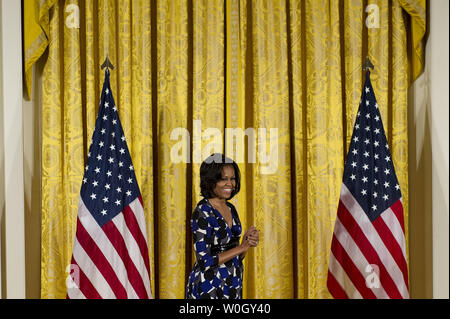 First Lady Michelle Obama waits on stage during the 2012 National Arts and Humanities Youth Program Awards in the East Room at the White House in Washington, November 19, 2012.  UPI/Kevin Dietsch Stock Photo