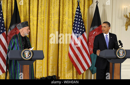 US President Barack Obama (R) makes remarks as Afghan President Hamid Karzai listens during a press conference in the East Room of the White House, January 11, 2013, in Washington, DC.  The leaders are discussing a long-term US troop presence as American military forces look at a 2014 withdrawal date from Afghanistan.       UPI/Mike Theiler Stock Photo