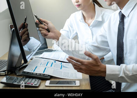 Stock exchange market concept, Team of investment trading or stock brokers having a consultation and analyzing with display screen and pointing on the Stock Photo