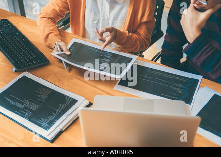 Professional Development programmer cooperating meeting and brainstorming and programming website working in a software and coding technology, writing Stock Photo