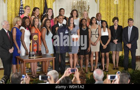 US President Barack Obama holds up a jacket presented by the UConn 2013 NCAA Women's basketball Champions as he welcomes them to the White House, July 31, 2013, in Washington, DC. Obama continued a tradition of welcoming sports champions to the White House and thanking them for their community service.          UPI/Mike Theiler Stock Photo