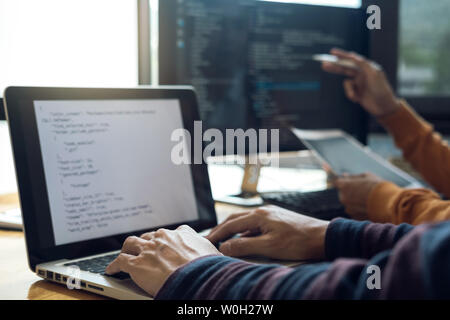 Professional Development programmer cooperating meeting and brainstorming and programming website working in a software and coding technology, writing Stock Photo