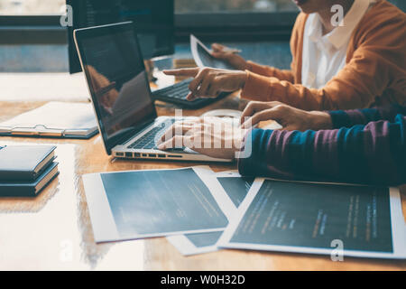 Professional Development programmer cooperating meeting and brainstorming and programming website working in a software and coding technology, writing Stock Photo