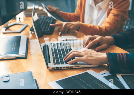 Professional Development programmer cooperating meeting and brainstorming and programming website working in a software and coding technology, writing Stock Photo
