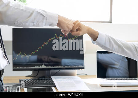 Finishing up a meeting, giving first bump of hand's two happy business people after contract agreement to become a partner, collaborative teamwork. Stock Photo