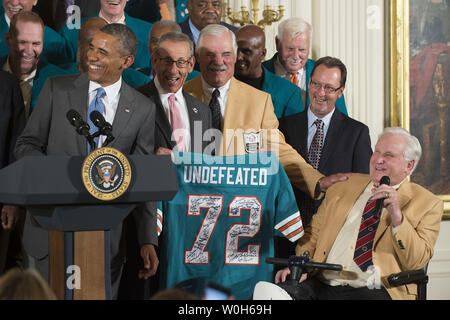 President Barack Obama jokes with members of the 1972 Miami Dolphins,  including offensive guard Larry Little (L), and quarterback Bob Griese,  during a ceremony honoring the Super Bowl VII Champions and their