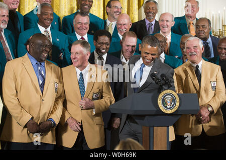 President Barack Obama jokes with members of the 1972 Miami Dolphins, including offensive guard Larry Little (L), quarterback Bob Griese (2nd-L) and fullback Larry Csonka, during a ceremony honoring the Super Bowl VII Champions and their perfect season, in the East Room at the White House on August 20, 2013. The 1972 Miami Dolphins are the only team in the NFL to go undefeated. UPI/Kevin Dietsch Stock Photo