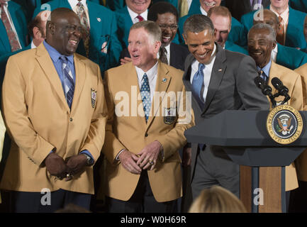 President Barack Obama jokes with members of the 1972 Miami Dolphins, including offensive guard Larry Little (L), and quarterback Bob Griese, during a ceremony honoring the Super Bowl VII Champions and their perfect season, in the East Room at the White House on August 20, 2013. The 1972 Miami Dolphins are the only team in the NFL to go undefeated. UPI/Kevin Dietsch Stock Photo