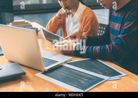 Professional Development programmer cooperating meeting and brainstorming and programming website working in a software and coding technology, writing Stock Photo