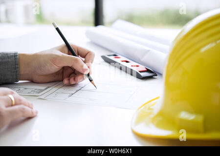 Construction engineering or architect hands working on blueprint inspection in workplace, while checking information drawing and sketching for archite Stock Photo