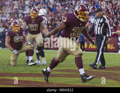 Washington Redskins Darrel Young is tackled by Minnesota Vikings' Jamarca  Sanford (33) and Chad Greenway (52) during the third quarter at FedEx Field  in Landover, Maryland on December 24, 2011. UPI/Kevin Dietsch