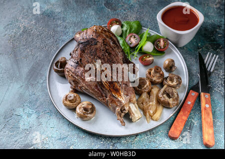 Halal food. Baked lamb with vegetables, spices, herbs, mushrooms and spicy sauce. Stock Photo