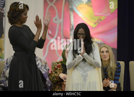First lady Michelle Obama applauds for Laxmi of India, an acid attack victim and advocate on behalf of acid attack victims, during an event to honor the recipients of the International Women of Courage Award at the U.S. Department of State, March 4, 2014, in Washington D.C.  The International Women of Courage Award annually recognizes women around the globe who have shown exceptional courage and leadership in advocating for womenÕs rights and empowerment, often at great personal risk.  UPI/Molly Riley Stock Photo