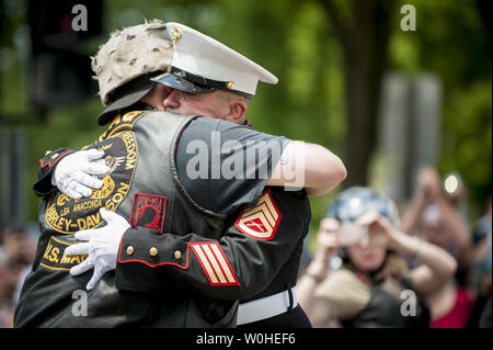 Former United States Marine Tim Chambers receives a hug from a rider as hundreds of thousands of motorcycle riders participate in the Rolling Thunder Motorcycle Rally XXVII, on Memorial Day weekend, May 25, 2014 in Washington, D.C. For the 12th consecutive year, former United States Marine Tim Chambers stands and holds a salute to honor fallen veterans as hundreds of thousands of motorcycle riders pass by him.   UPI/Pete Marovich   UPI/Pete Marovich