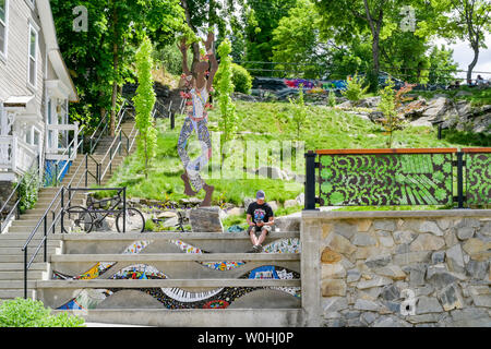 Man sitting on steps in funky Park setting, Nelson, British Columbia, Canada Stock Photo
