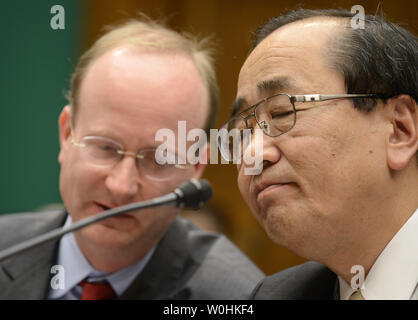 Takata Corporation Senior VP for Global Quality Assurance Hiroshi Shimizu (R), clarifies a question with his interpreter as he appears to testify before the House Energy and Commerce Committee on the Takata airbag ruptures and recalls, on Capitol Hill, December 3, 2014, in Washington, DC. A number of airbags which have deployed have sent deadly projectiles into auto passengers.    UPI/Mike Theiler Stock Photo