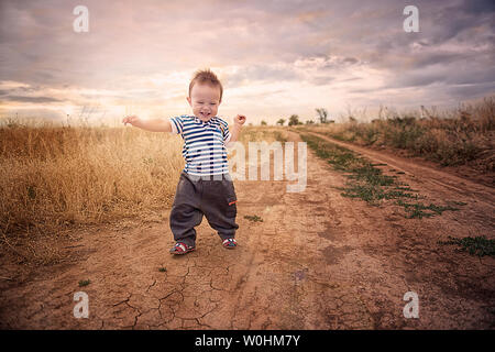 Baby's first steps in nature. The first independent steps. Stock Photo