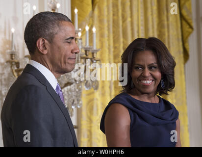 First lady Michelle Obama smiles at President Barack Obama after delivering remarks during an event on expanding efforts to help adolescent girls worldwide attend and stay in school, at the White House in Washington DC, March 3, 2015.  Photo by Molly Riley/UPI Stock Photo