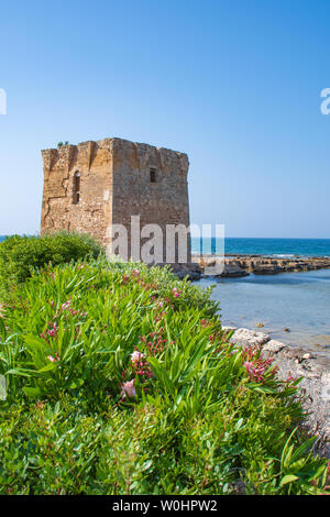 Baroque watchtower, beautiful old tower in San Vito, Polignano a Mare, Bari, Puglia, Italy with with blue sea, stone wall and flowers, Mediterranean Stock Photo