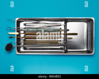 Dental tools in the tray on blue background. Dental health concept Stock Photo