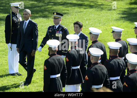 U.S. President Barack Obama (L) escorts Japanese Prime Minister Shinzo Abe (R) as they review the troops during the welcoming ceremony on the South Lawn of the White House, April 28, 2015, in Washington, DC.        Photo by Mike Theiler/UPI Stock Photo