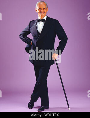 African-American male wearing a tuxedo and holding a Walkingstick Stock Photo