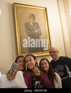 A family takes a 'selfie' photo in front of a portrait of President John F. Kennedy during a White House tour in Washington, D.C. on July 1, 2015. Today the White House lifted a 40-year band on tourist taking pictures inside the White House. Photo by Kevin Dietsch/UPI Stock Photo