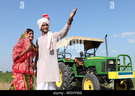 Happy Indian farmer couple standing in mustard field enjoying the ...