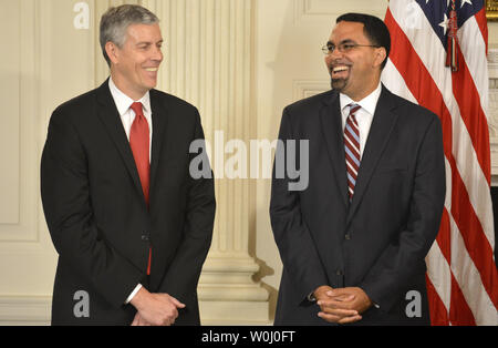 Outgoing Secretary of Education Arne Duncan (L) and nominee John B. King, Jr. share a laugh as they listen to remarks by as U.S. President Barack Obama, in the State Dining Room of the White House, October 2, 2015, in Washington, DC. Obama then held a news conference and responded to questions on gun safety, Russia's intervention in Syria and dealings with the Republican Congress.      Photo by Mike Theiler/UPI Stock Photo