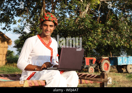 Portrait of an Indian farmer using a laptop Stock Photo