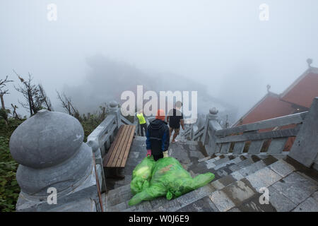 Sapa, Vietnam - Sep 08 2017 : Staff man walking down stair with dragging big garbage bag to leave Stock Photo