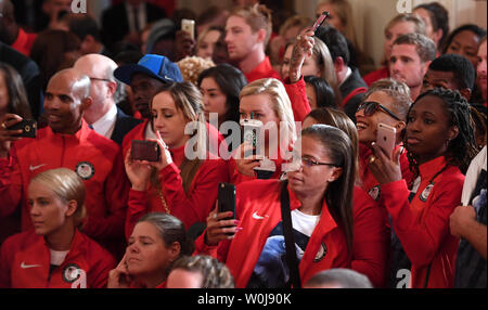 Olympic team members use their smartphones during a welcoming ceremony for the USA Olympic and Paralympic Teams in the East Room of the White House in Washington, DC on September 29, 2016.   The teams were honored for their success at the Rio Olympic Games this summer.    Photo by Pat Benic/UPI Stock Photo