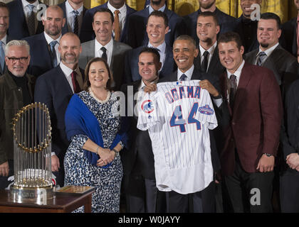 President Barack Obama smiles as Chicago Cubs first baseman Anthony Rizzo  and Chicago Cubs President of Baseball Operations Theo Epstein (R) present  him with a 'Chicago' Cubs away jersey during a ceremony