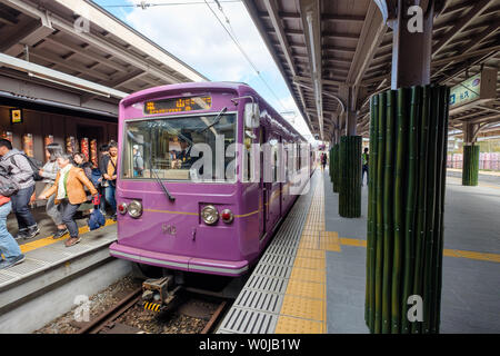 Kyoto, Japan - Nov 11 2017 : Traditional identity train purple parked on platform with passengers at arashiyama station Stock Photo