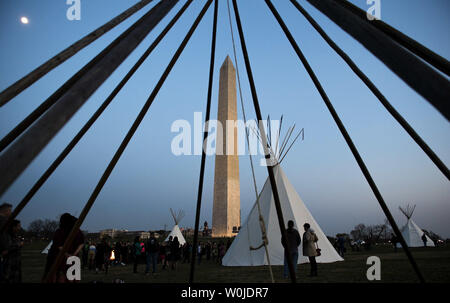 People gather near tepees set up by the Standing Rock Sioux Tribe and Native Nations Rise in protest of the Dakota Access Pipeline, near the Washington Monument on March 9, 2017 in Washington, DC. Activists and have set up teepees on the National Mall as part of a three day protest culminating in a protest march tomorrow to the White House in opposition of the Trump Administration's approval of the controversial Dakota Access pipeline through Native land. Photo by Kevin Dietsch/UPI Stock Photo