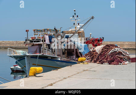 Chania, Crete, Greece, June 2019. A commercial fishing boat and nets alongside in Chania fishing port, Greece. Stock Photo