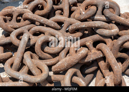 Chania, Crete, Greece, June 2019. Ship's anchor chain with close up of the rusting links on the quayside. Stock Photo